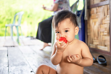 Cute Asian baby girl eating watermelon, Female kid enjoy eating watermelon  