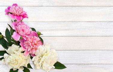 Fototapeta na wymiar Bouquet of pink and white peonies on background of white painted wooden planks with space for text. Top view, flat lay