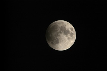 View, of a phase, of the lunar eclipse through a telephoto lens in Turin, Italy