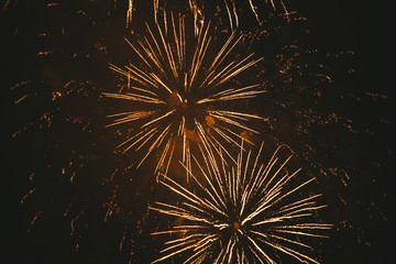 Close-up gold festive fireworks on a black background. Abstract holiday background