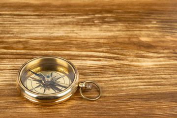 Fototapeta na wymiar Compass on wooden background, concept for direction transportation and travel, with copy space
