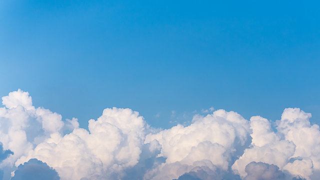 Top of white fluffy clouds and blue sky background