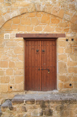 Fototapeta na wymiar Wooden outside door in stone wall