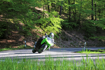 Sportlicher Motorradfahrer auf einer kurvenreichen Landstraße