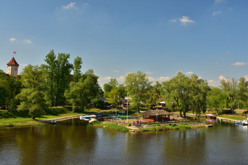 Fototapeta na wymiar Drzewa i marina nad rzeką w pogodny dzień.