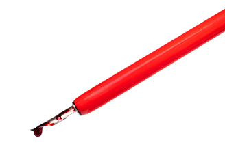 red ink drop dripping from nib of dip pen
