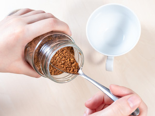 top view of spoon in glass jar with instant coffee