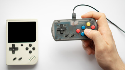 hand holding retro games isolated on a white background. focus on console and hands. 