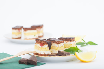 Pieces of lemon sponge cake with chocolate glaze on a plate. Homemade lemon cake.