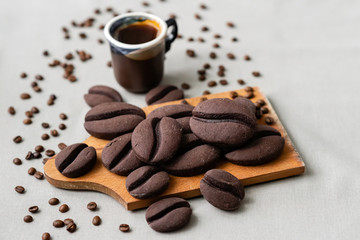 ginger biscuits with cocoa in the form of coffee beans on a wooden board on a gray background