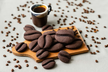 ginger biscuits with cocoa in the form of coffee beans on a wooden board on a gray background