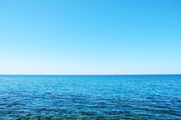 Beautiful seascape on sunny day with wind patterns on calm azure water and clear blue sky without...