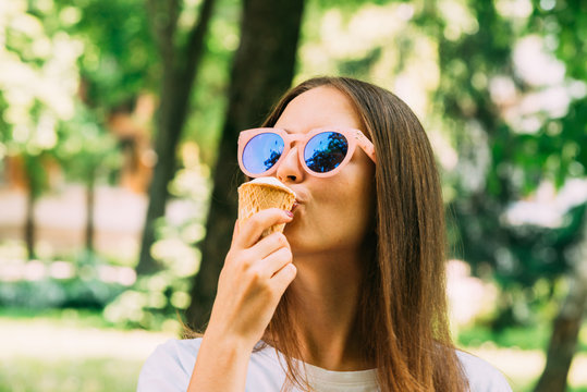 Outdoor portrait young hipster crazy girl eating ice cream summer weather mirror sunglasses