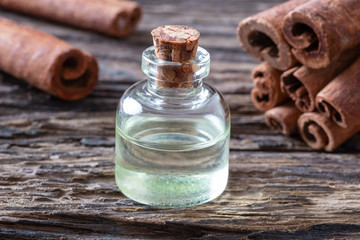 A bottle of cinnamon essential oil with cinnamon sticks