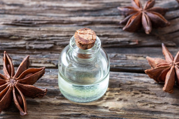 A bottle of star anise essential oil with dried star anise