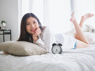 Close up of a happy young woman smile while lying on the bed at home on morning.