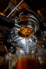 Creamy espresso coffee pouring from the coffee machine