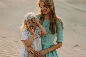 happy mother with her little daughter in the desert