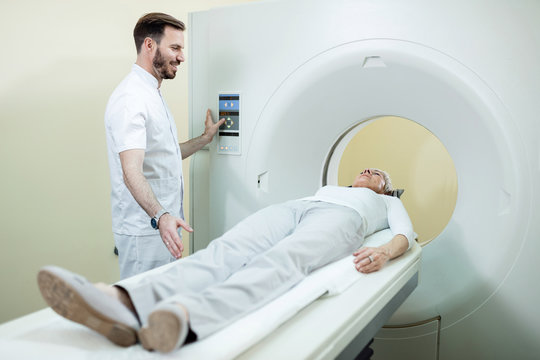 Happy male radiologist and patient during CT scan examination in the hospital.