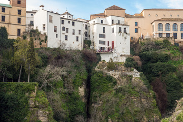 Fototapeta na wymiar Residential buildings in the Spanish city of Ronda. Houses above the gorge of El Tajo. City over the abyss.