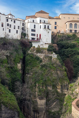 Fototapeta na wymiar Residential buildings in the Spanish city of Ronda. Houses above the gorge of El Tajo. City over the abyss.