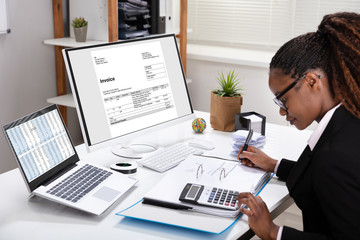 Businesswoman Using Calculator Calculating Invoice