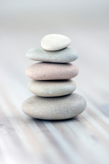 Fototapeta na wymiar Harmony and balance, cairns, simple poise stones on wooden light white gray background, simplicity rock zen sculpture