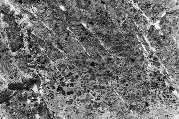 Vintage monochrome background. Rough painted wall of black and white color. Imperfect plane of grayscale. Uneven old decorative backdrop. Texture of black-white. Monochromatic ornamental stony surface