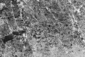 Vintage monochrome background. Rough painted wall of black and white color. Imperfect plane of grayscale. Uneven old decorative backdrop. Texture of black-white. Monochromatic ornamental stony surface
