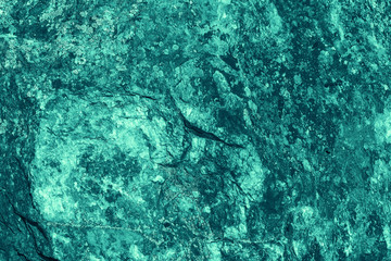 Vintage azure background. Rough painted wall of turquoise color. Imperfect plane of cyan colored. Uneven old decorative toned backdrop of aqzure tint. Texture of teal hue. Ornamental stony surface.