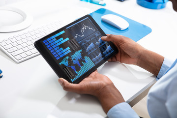 Person's Hand Pointing On Graph At Tablet