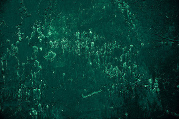 Vintage green background. Rough painted wall of emerald color. Imperfect plane of virid colored. Uneven old decorative toned backdrop of green tint. Texture of emerald hue. Ornamental stony surface.