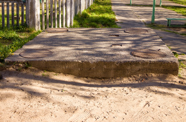the well of a heating main covered with concrete with four hatches