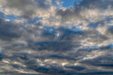 The sky with dark clouds illuminated by the setting sun