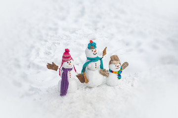 Happy winter snowman family. Mother snow-woman, father snow-man and kid wishes merry Christmas and Happy New Year. Merry Christmas and happy New Year greeting card with copy-space.