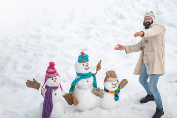 Happy winter snowman family. Happy snow man and bearded man on sunny winter day. Mother snow-woman,...