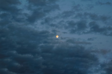 The sky with dark clouds illuminated by the setting sun