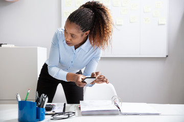 Businesswoman Taking Photograph In Office