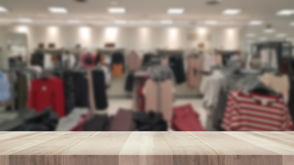 Empty wood table and blurred clothing store, product display montage