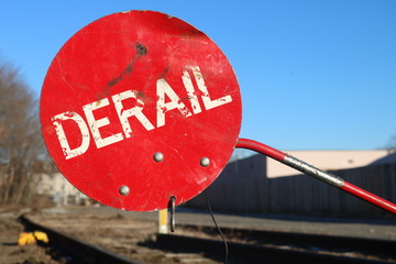 Red derail warning symbol sign on old abandoned railroad tracks 