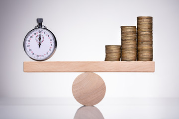 Stop Watch And Stack Of Coins On Scale
