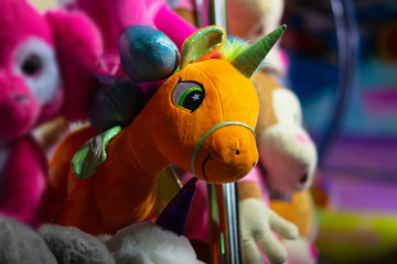 A pretty unicorn as a stuffed animal on a funfair to win at a gamble.