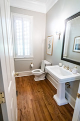 Fototapeta na wymiar small guest bathrom with traditional ceramic sink and hardwood floors 