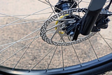 gray metal spokes on the black wheel of a bicycle