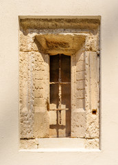 An ancient stone window with a window grid.