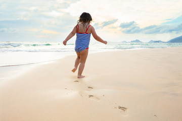 Fototapeta na wymiar Little Girl Running On The Idyllic Beach