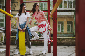 Fototapeta na wymiar Young happy hipster girls staying with skateboards