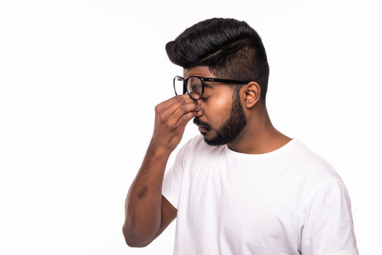 Studio shot of young stressed Indian man having headache isolated on white background