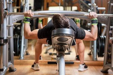sport, bodybuilding, lifestyle and people concept - young man with barbell flexing muscles and...