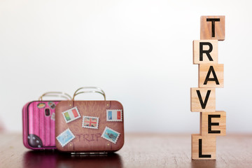 Travel Suitcases and Travel word on wooden table with copy space